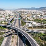 Attiki Odos toll road interchange with National motorway in Attica, Athens, Greece. Aerial drone view of multilevel junction highway